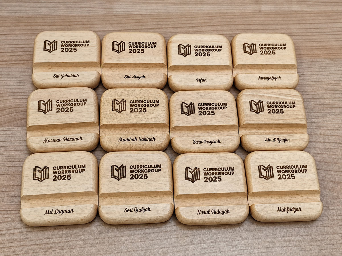 Square wooden phone stands with rounded corners, customised with the customer’s “Curriculum Workgroup 2025” artwork and individual names. 