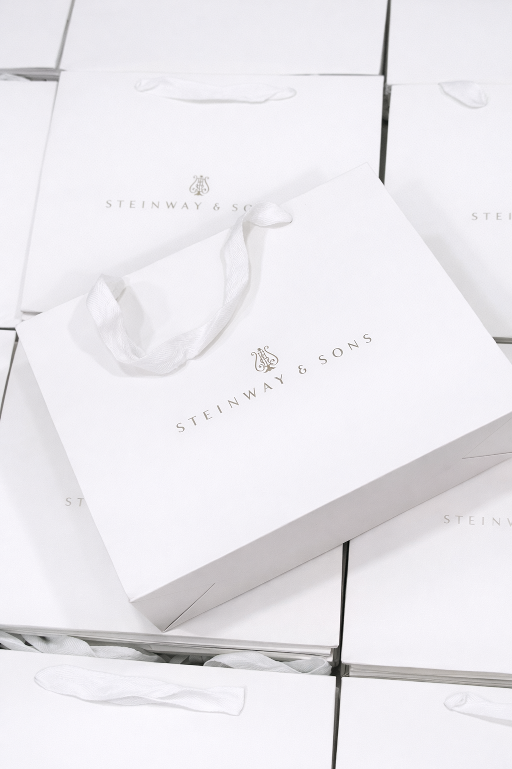 White ribbon gift bag personalised with Steinway & Sons logo